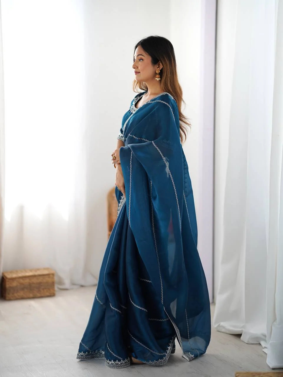 Teal blue silk saree with silver thread and sequin work — side profile view