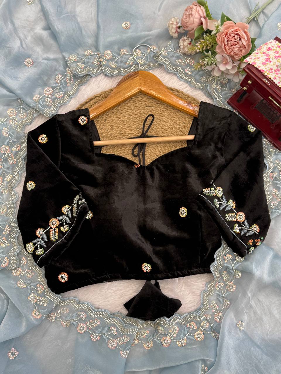 Black velvet blouse design with embroidery paired with sky blue saree