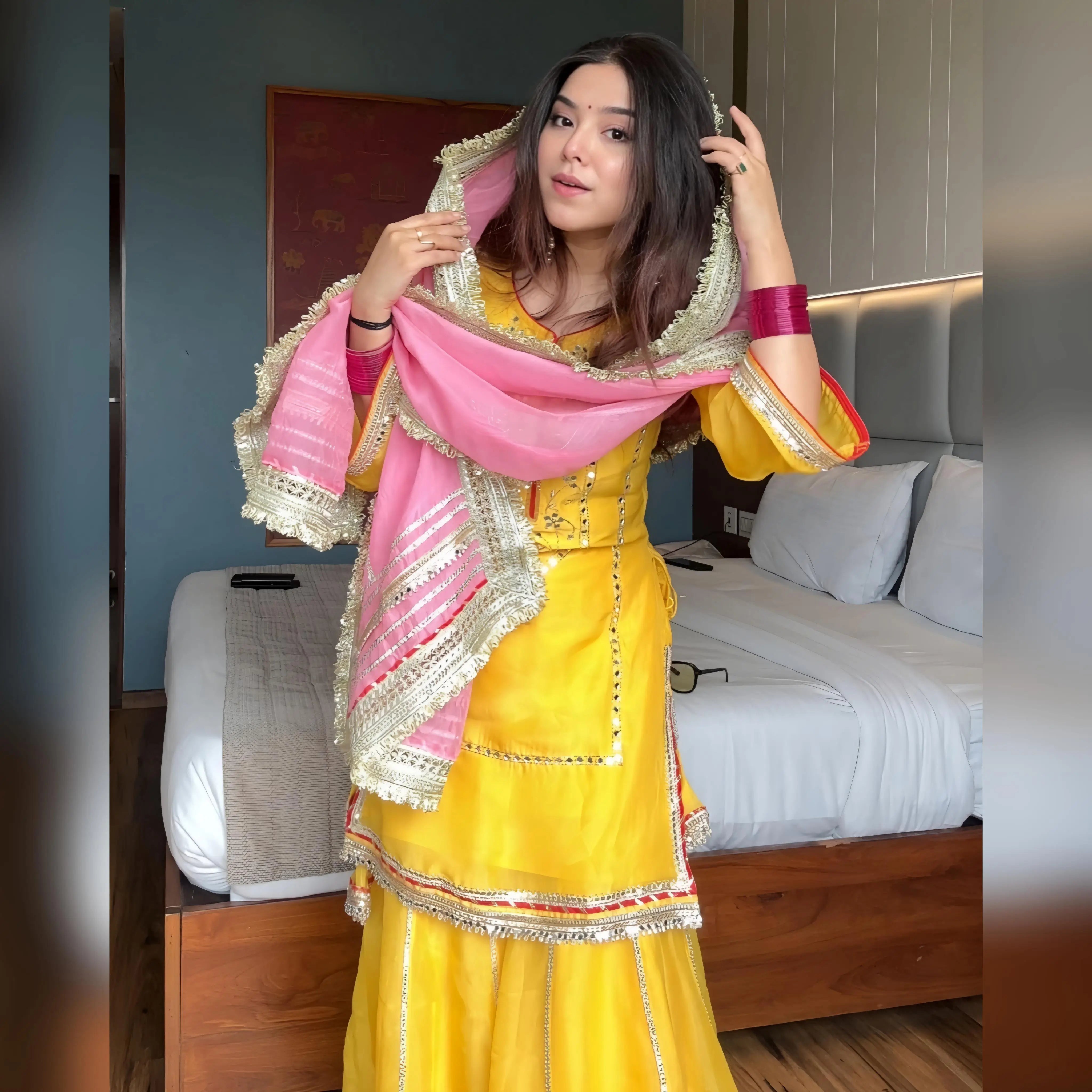 Baby pink dupatta draped on yellow mirror work sharara set for Haldi ceremony